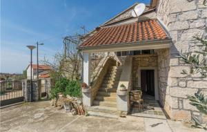 a stone house with a staircase in a yard at Two-Bedroom Apartment In Vrsar in Vrsar