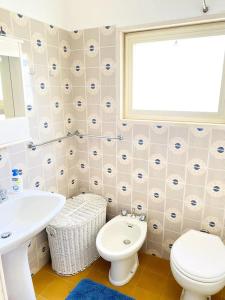 a bathroom with a white toilet and a sink at Il Foscolo in Torre dell'Orso +14 photos