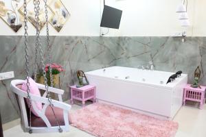 ein Badezimmer mit einer Badewanne und einem rosa Teppich in der Unterkunft Modern Jacuzzi Spa Tub 1BHK Suite South Delhi (3) in Neu-Delhi + 33 Fotos