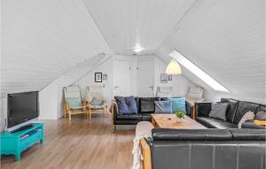 a living room with a couch and a tv at Nice Home In Glesborg With Sauna in Fjellerup Strand