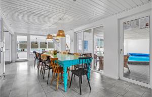 a dining room with a blue table and chairs at Nice Home In Glesborg With Sauna in Fjellerup Strand