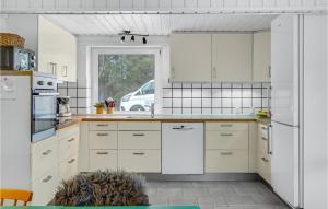 a white kitchen with white cabinets and a window at Nice Home In Glesborg With Sauna in Fjellerup Strand