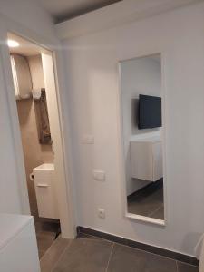a bathroom with a mirror and a tv on a wall at Apartments R&B in Baška +29 photos
