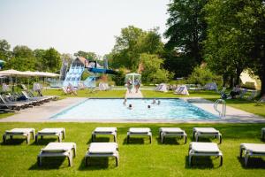 MisteGlamping Winterswijk的游泳池设有躺椅,里面有人