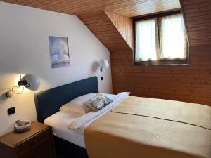 a bedroom with a bed and a window at Hôtel La Fontaine in Saint-Imier