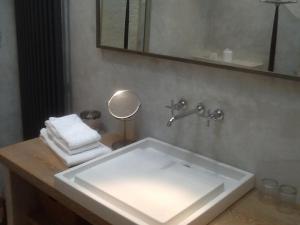 un bagno con lavandino, specchio e asciugamani di B&B Château Légier a Fontvieille Altre 14 foto