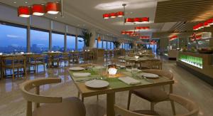 a restaurant with tables and chairs and windows at The Westin Mumbai Garden City in Mumbai
