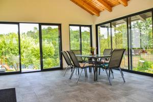 a dining room with a table and chairs and windows at Vila MOON in Bezdead