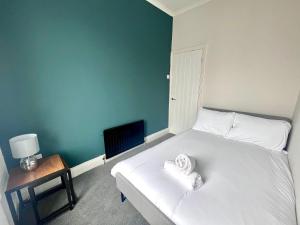 a bedroom with a bed with two towels on it at 3 BDRM close to beach&city in North Shields