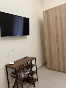 a room with a table and a television on a wall at Re Umberto 311 in Naples