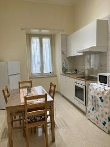 a kitchen with a table and chairs and a kitchen with white cabinets at Re Umberto 311 in Naples
