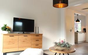 a living room with a tv on top of a dresser at Pilsumer Küstenhuuske in Krummhörn