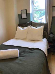 een slaapkamer met een bed met witte kussens en een raam bij Free Parking, City Centre,quiet,netflix in Town Moor