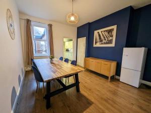 ゲーツヘッドにあるEnjoy 5 Br House Near The Cityのテーブルと冷蔵庫のあるダイニングルーム