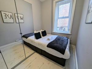 ゲーツヘッドにあるEnjoy 5 Br House Near The Cityのベッドルーム(鏡にベッド1台付)