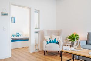 a living room with a chair and a mirror at App 8u Heimatliebe in Dranske