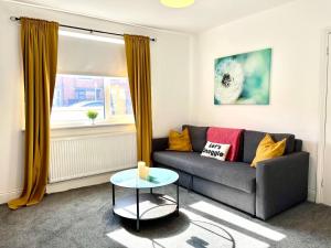 アシントンにあるSpacious 3 Bed Northumberland Long Stay Discountのソファとテーブルのあるリビングルーム +2枚の写真