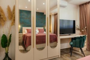 a bedroom with a bed and a television in a room at VILLA G., Relaxing and Unique nest of Enjoyment in Imotski