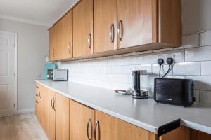 a kitchen with wooden cabinets and a counter top at Enjoy a spacious 3 BR home in Sunderland +10 photos