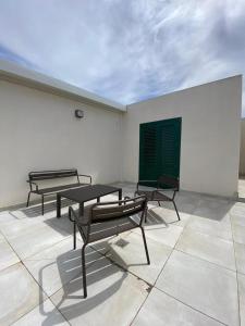three benches sitting on a room with a wall at Historico Loft & Rooms Palazzo Adragna XIX in Trapani