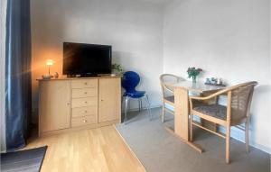 un salon avec une télévision, une table et des chaises dans l'établissement Beautiful Apartment In Nexø With Sauna, à Strandby Gårde