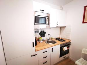 a small kitchen with a sink and a microwave at ALDIRA Studio Arena Nationala in Bucharest
