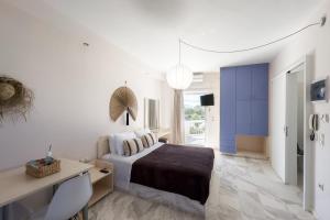 a bedroom with a bed and a desk and a television at Karystos Mare Apartments in Karistos