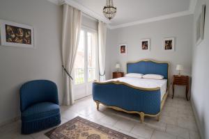 a bedroom with a blue bed and a chair at Maison familiale avec jacuzzi, quartier calme in Avignon