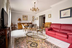 a living room with a red couch and a table at Maison familiale avec jacuzzi, quartier calme in Avignon
