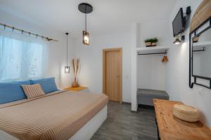 a bedroom with a large bed and a table at Dorkas Luxury Rooms&Apartments in Livadakia