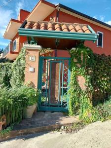 une maison rouge avec une porte bleue devant elle dans l'établissement Villa Lucia, à Castelvenere