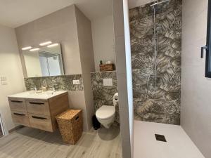 a bathroom with a toilet and a sink and a shower at Maison du Bois, pinède et océan in Saint-Jean-de-Monts +15 photos