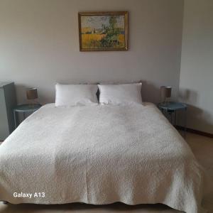 明乔河畔的瓦雷奇奥Casa Magnolia的卧室配有白色的床和两张桌子 更多2张照片