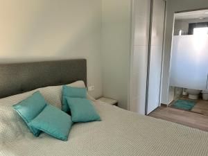 a bedroom with a bed with two blue pillows at SPANISH SUN - 500 m from the beach in Arenales del Sol +32 photos