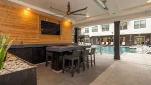an outdoor bar with a pool and a tv at EQR Weaver Austin in Austin