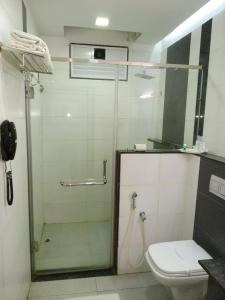 a bathroom with a shower with a toilet and a phone at Hotel Merlin International in Trichūr +32 photos