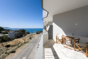 a white house with a view of the ocean at Karystos Mare Apartments in Karistos