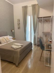 a bedroom with a bed and a desk and a chair at Manzoni 116 in Bari