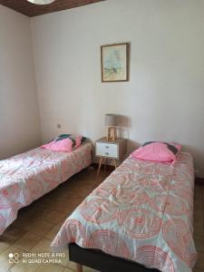 Un dormitorio con dos camas y una mesa con lámpara. en Gîte Bégonia dans un cadre idyllique, idéalement situé, en Castels 9 fotos más