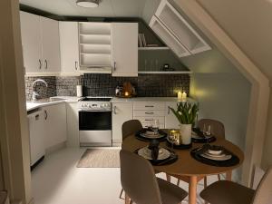 a kitchen with white cabinets and a table and chairs at High rated private appartment 350 m from Ålesund center with free parking in Ålesund