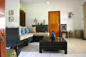 a living room with a couch and a table at Paodise Guesthouse in La Digue