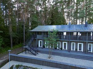 a house with a staircase in the middle of a forest at Svedresort in Švedriškė