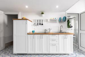 een keuken met witte kasten en een spoelbak bij La cianciola in Gaeta +14 foto's