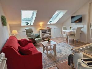 a living room with a red couch and a table at Wohnung Adlerhorst in Eversen-Heide in Eversen