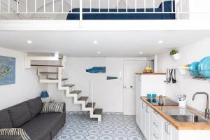 een woonkamer met een bank en een trap bij La cianciola in Gaeta