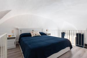 een slaapkamer met een bed met een blauwe deken bij La cianciola in Gaeta