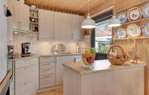 a kitchen with white cabinets and a counter with a bowl of vegetables at 3 Bedroom Gorgeous Home In Gilleleje in Gilleleje
