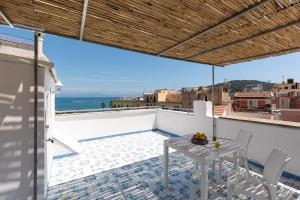 een balkon met een tafel en stoelen en de oceaan bij La cianciola in Gaeta