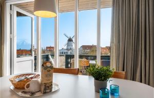 Una mesa de comedor con vistas a un molino de viento. en Mølleparken, en Gudhjem