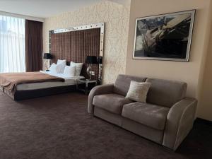 a hotel room with a bed and a couch at Apartaments Sea in Odesa +24 photos